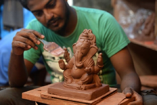 indian artisan dattadri kothur creates an eco friendly clay idol of elephant headed hindu god lord ganesha at the 039 tree ganesha 039 workshop in mumbai photo afp