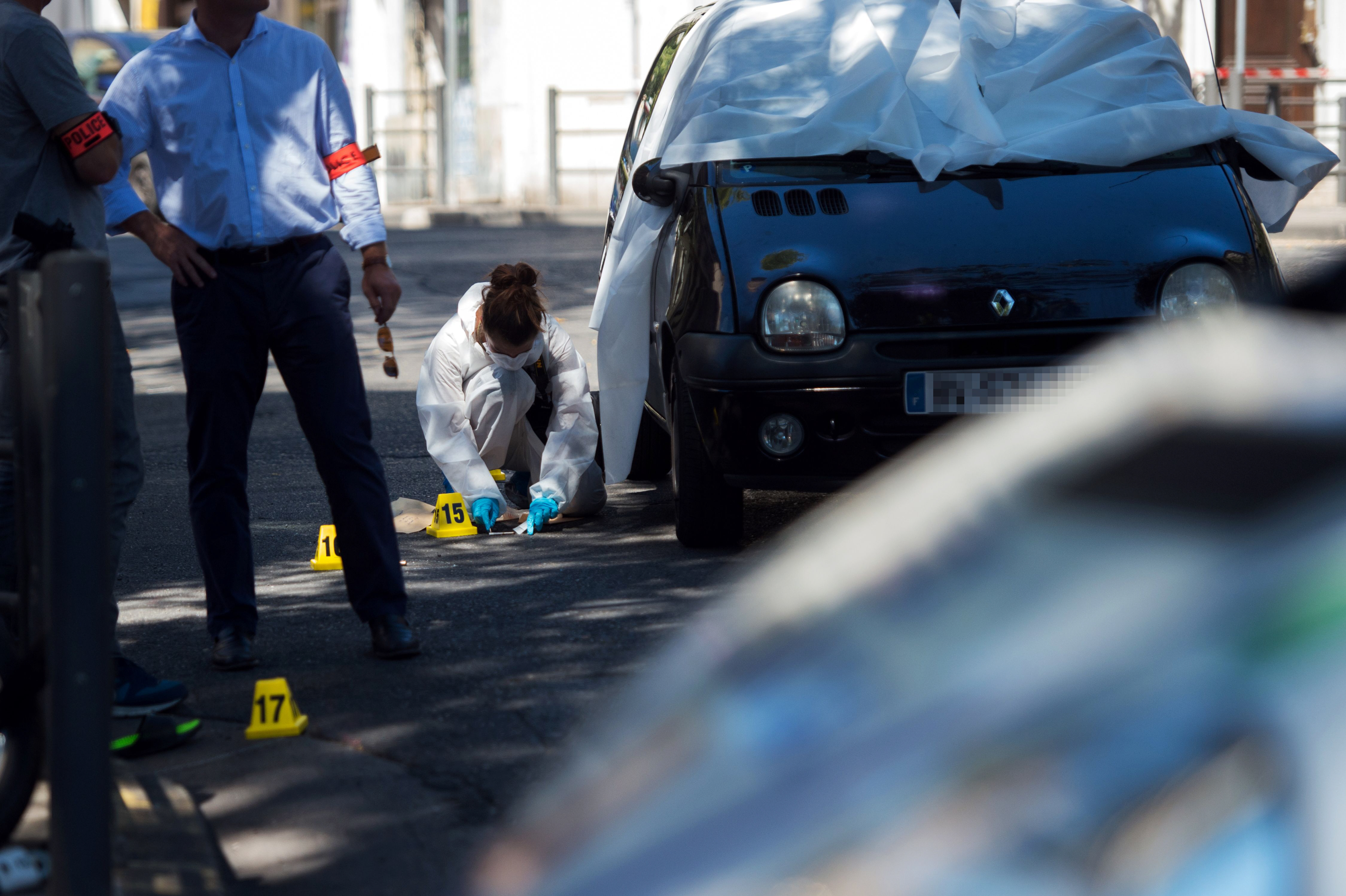 a forensic police officer investigates by the car where two men in their twenties were shot dead near the train station saint charles in marseille southern france on august 7 2016 photo afp