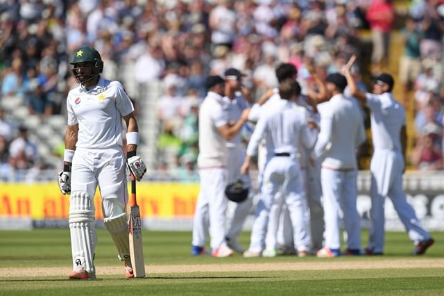 misbahul haq walks back to the pavilion as england players celebrate at edgbaston in birmingham on august 7 2016 photo afp