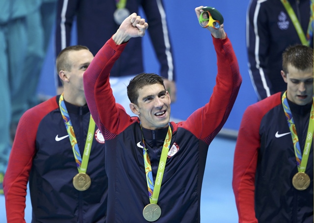 michael phelps poses with his gold medal as he celebrates with his team photo reuters