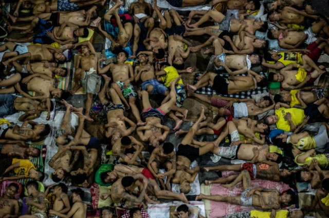 inmates sleep on the ground of a basketball court inside the quezon city jail at night in manila on july 19 2016 photo afp