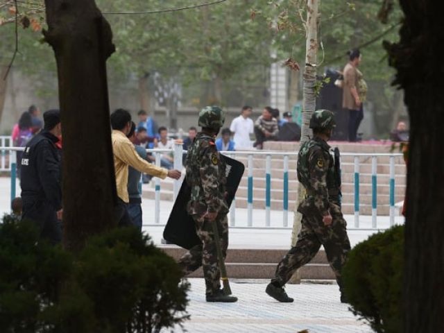 paramilitary police patrol beside the central square in hotan in china 039 s western xinjiang region photo afp