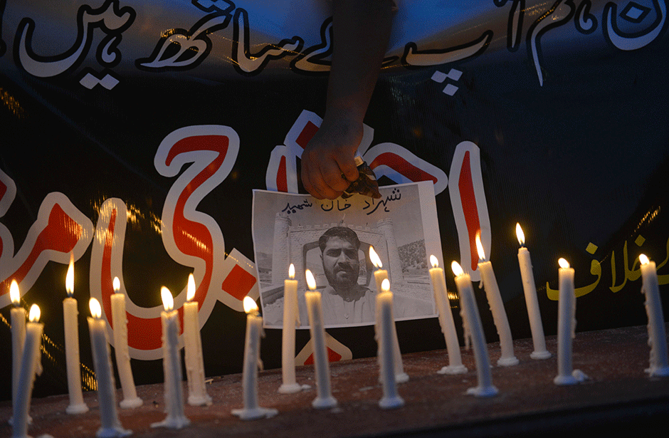 a journalist holds a poster bearing an image of a news cameraman killed in a suicide bombing during a rally to pay tribute to quetta victims photo afp