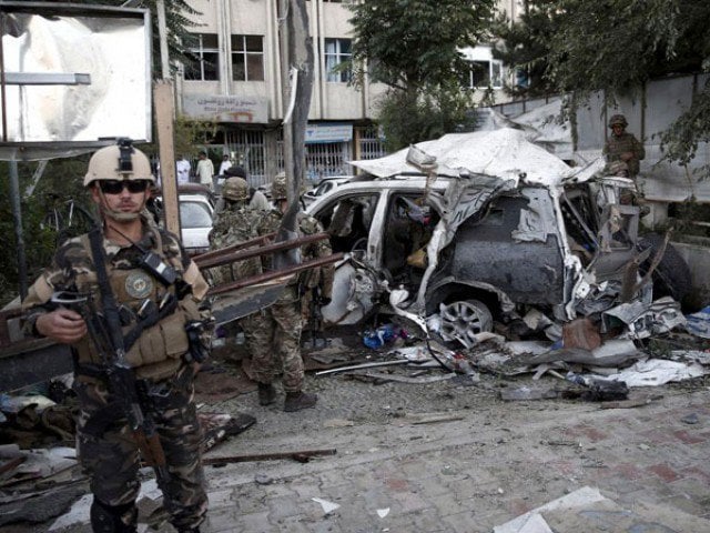 afghan security personnel l keeps watch next to a damaged car belonging to foreigners after a bomb blast in kabul afghanistan august 22 2015 photo reuters