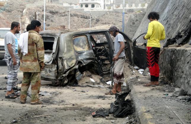 people look at the wreckage of a car at the site of the a car bomb attack that killed the governor of yemen 039 s southern port city of aden photo afp