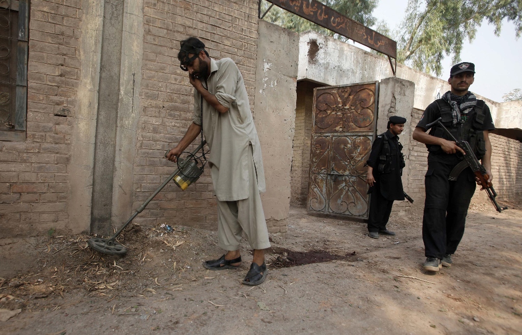 a security official uses a metal detector to survey the site of the blast photo reuters