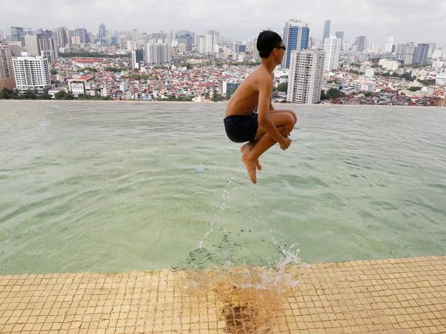 A boy jumps into the water at the gold-plated infinity pool of the newly inaugurated Dolce Hanoi Golden Lake luxury hotel in Hanoi, Vietnam. PHOTO: REUTERS