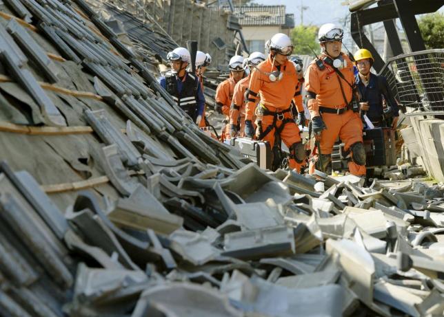 firefighters walk among collapsed houses caused by an earthquake in southern japan photo reuters