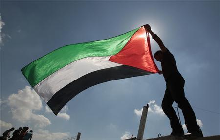 a palestinian holds a flag during a protest near the erez border crossing between israel and northern gaza strip october 5 2011 in solidarity with palestinian prisoners held in israeli jails reuters ismail zaydah