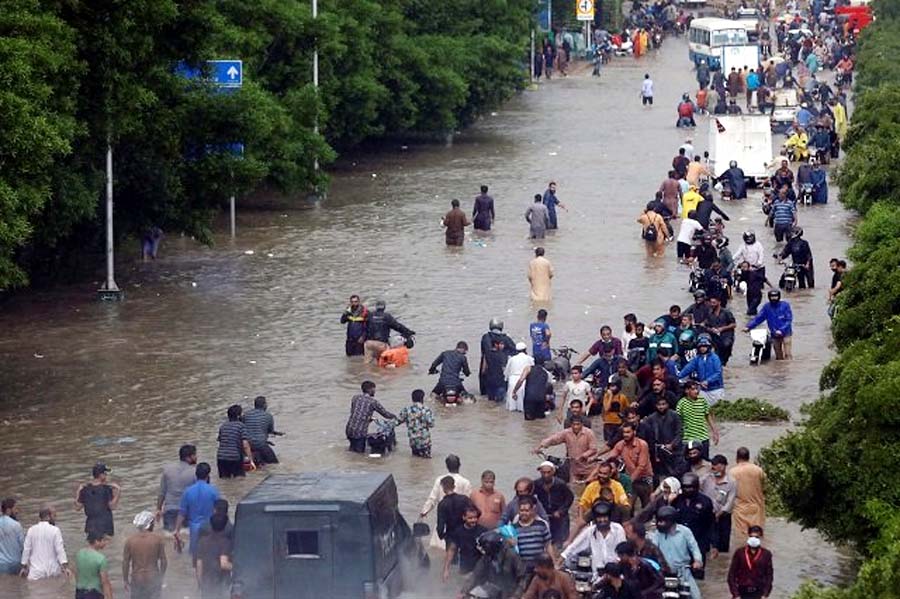people wade through the flooded road during monsoon rain in karachi photo reuters