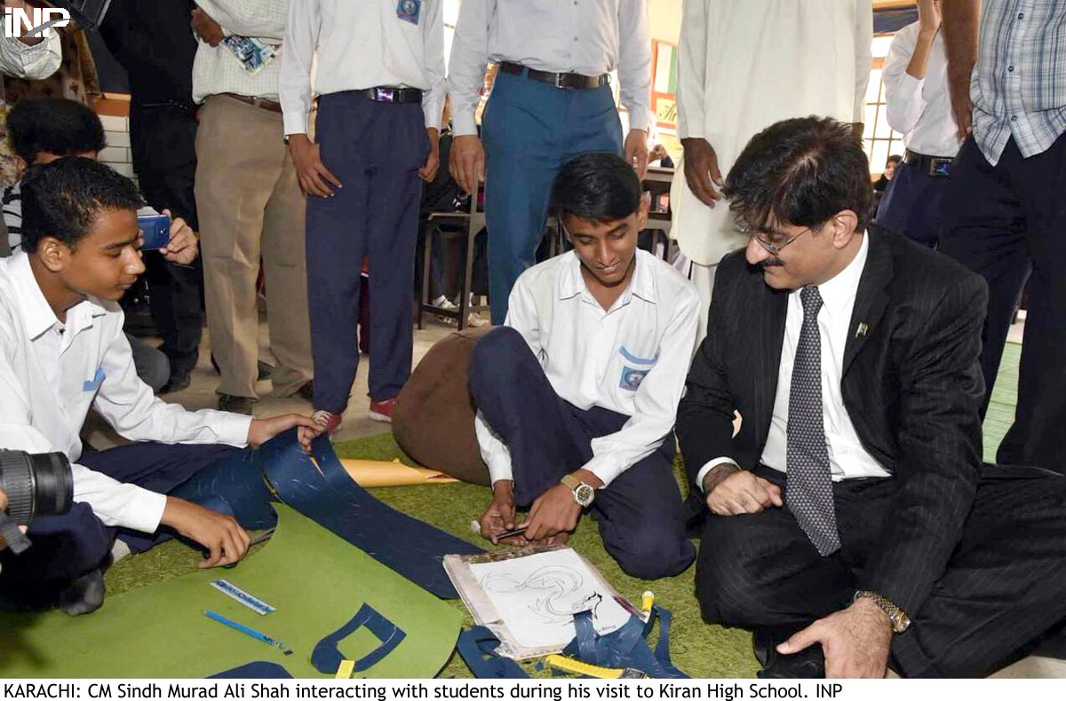 the children sang national songs for him and presented him with flags he sat with students on the floor of the classroom and spoke to them and appreciated their artwork photo inp