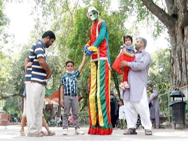 a ten foot clown poses with his young fans photo express