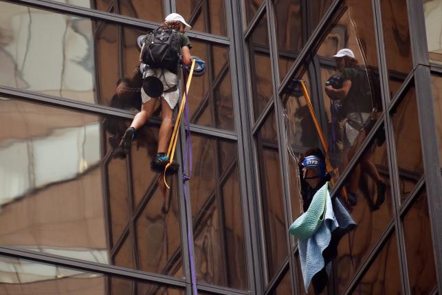 officers from the nypd attempt to detain a man as he climbs the outside of trump tower photo reuters