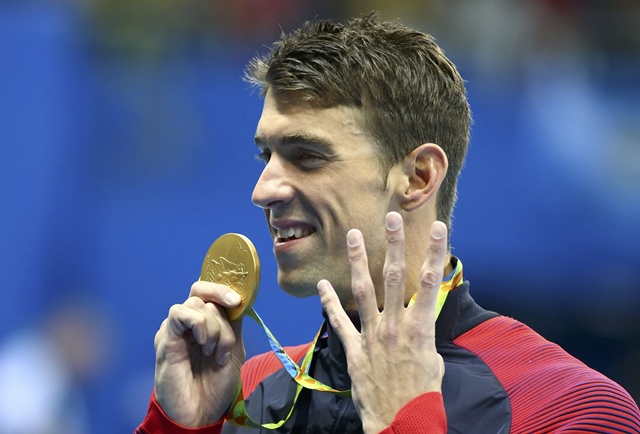 michael phelps gestures to indicate the four gold medals he has won at this olympic games as he poses with his gold medal photo reuters