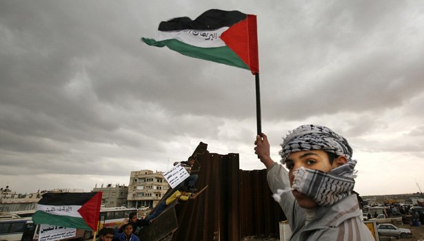 a palestinian waves a flag near a destroyed section of the border wall between the gaza strip and egypt january 29 2008 israel will not stand in the way of palestinian president mahmoud abbas taking control of gaza 039 s breached border with egypt as part of a deal to sideline hamas islamists who rule the enclave officials said on tuesday photo reuters