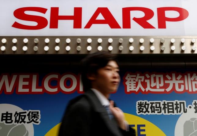 a logo of sharp corp is seen above a chinese tourist standing outside an electronics retail store in tokyo japan march 30 2016 photo reuters