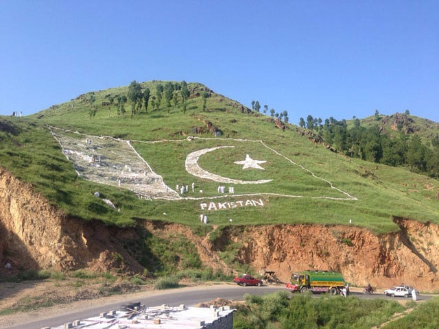 a view of pakistan 039 s national flag painted at a hill in mansehra photo express