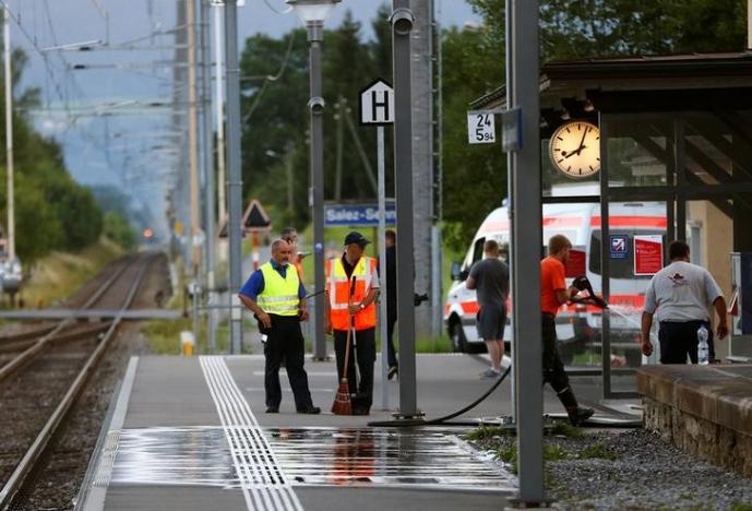 a swiss police officer stands near workers cleaning a platform after a 27 year old swiss man 039 s attack on a swiss train at the railway station in the town of salez switzerland august 13 2016 photo reuters