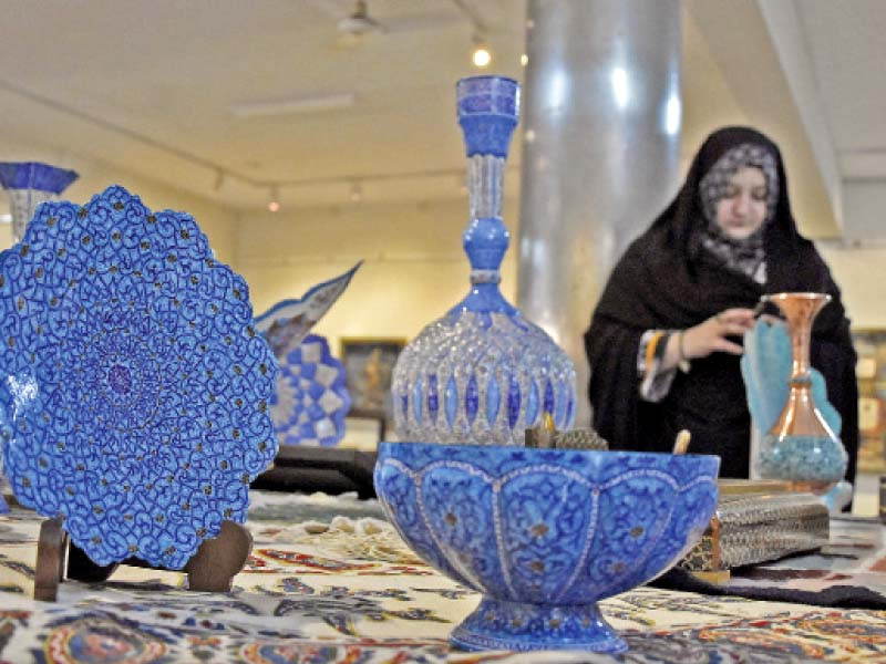 a woman looks at handicraft items during an exhibition of calligraphy and handicrafts at the rawalpindi arts council to mark independence day photo online