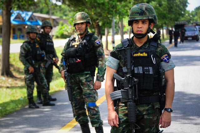 thai soldiers watch as a forensic unit inspects the scene of an attack following two roadside bomb blasts at four separate locations by suspected separatist militants in the bacho district of thailand 039 s restive southern province of narathiwat on august 15 2016 photo afp