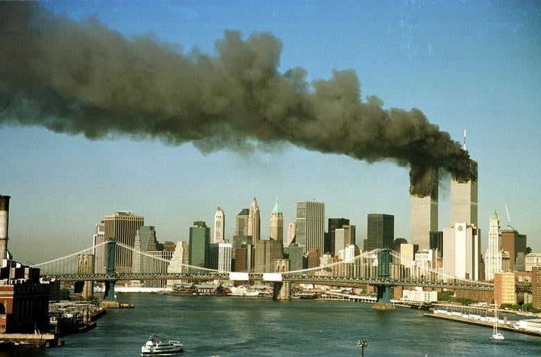 The towers of the World Trade Center pour smoke shortly after being struck by hijacked commercial aircraft, September 11, 2001. [Photo: Reuters]