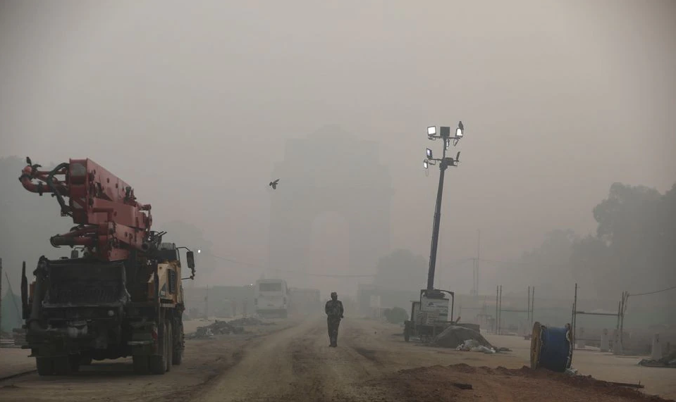 An Indian paramilitary soldier walks near India Gate which is shrouded in smog, in New Delhi, India, November 5, 2021. REUTERS