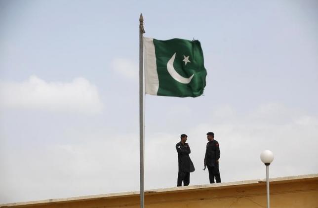 a pakistani flag flies on a mast as paramilitary frontier corps soldiers talk while guarding at karachi 039 s district malir prison august 23 2013 photo reuters