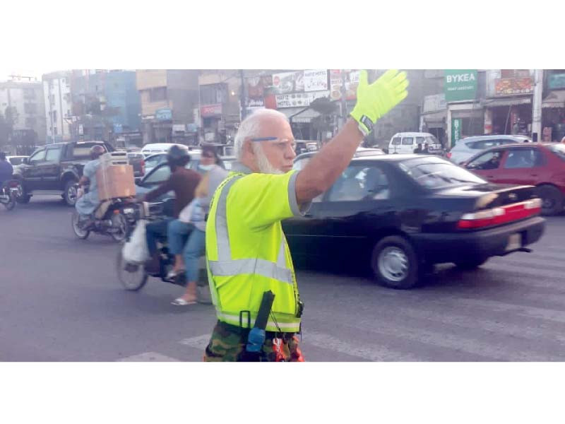 raja arshad ali controls traffic at a busy intersection on korangi road near national medical centre photo express