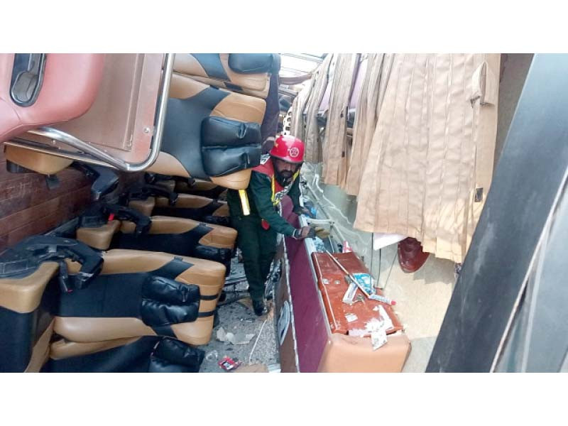 a rescue worker carefully navigates the mangled cabin of an overturned bus near khushab photo express