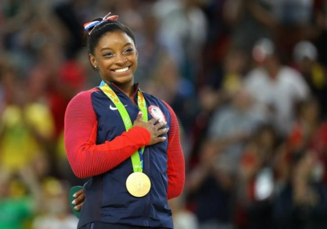simone biles places her hand on her heart as her national anthem is played photo reuters simone biles places her hand on her heart as her national anthem is played photo reuters