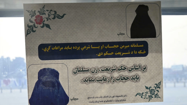 a poster ordering women to cover up is seen at a gate of kabul s airport afp a poster ordering women to cover up is seen at a gate of kabul s airport afp