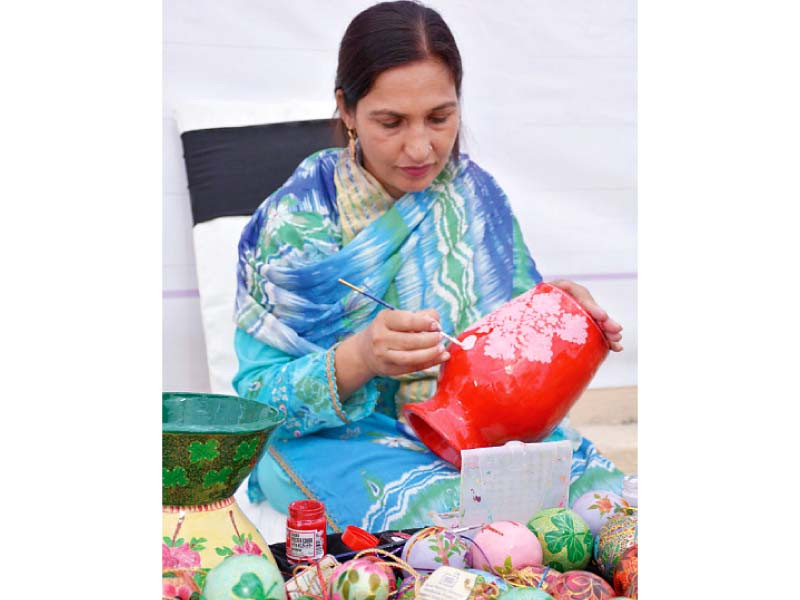 a participant of the 15th annual rural women conference paints a beautiful clay pot photo express