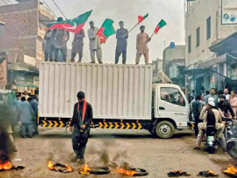 pti supporters burn tyres and stand atop a truck during one of the protests staged across the province photo nni