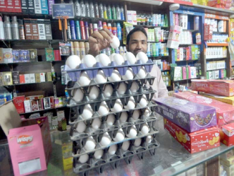 a shopkeeper arranges eggs at his shop poultry farmers have warned of hike in price of eggs and poultry due to shortage of chicken feed photo jalal qureshi express