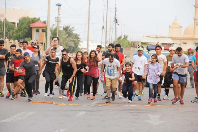 a large number of people participate in the marathon organised to raise awareness about thalassemia above while a woman carries the youngest participant early sunday morning below photos ayesha mir express