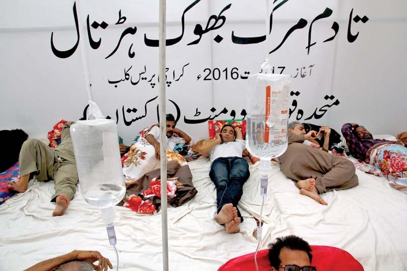 mqm leader amir khan lies among party workers at the hunger strike camp outside karachi press club on sunday photo athar khan express