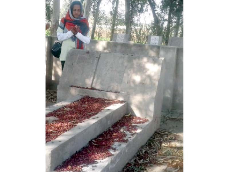 a girl offers prayers at arfa karim s grave someone has vandalised the grave and removed the headstone photo express