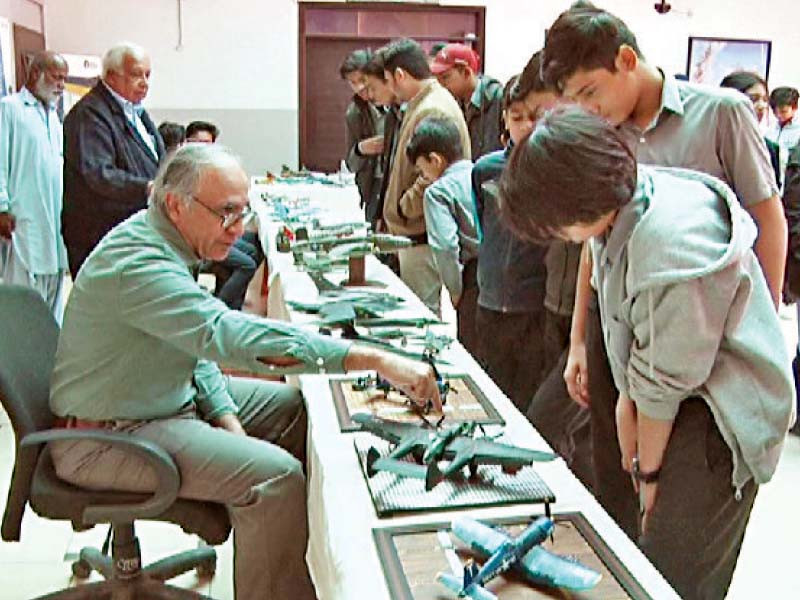 a plastic model maker explains his craft to a student during an exhibition held at the aviation institute of management photo express