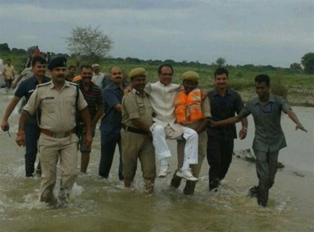 shivraj singh chouhan cm madhya pradesh state was seen being carried by officials through ankle deep muddy water photo source twitter sagar patil
