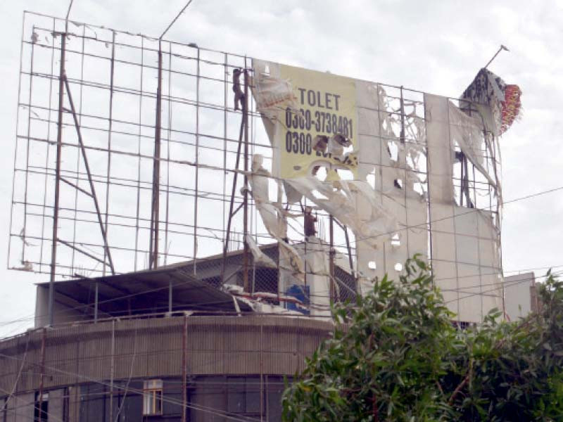 workers remove panaflex sheet from a billboard to prevent it from flying away and causing threat to life and property as karachi experiences strong winds triggered by cyclone biparjoy photo jalal qureshi express