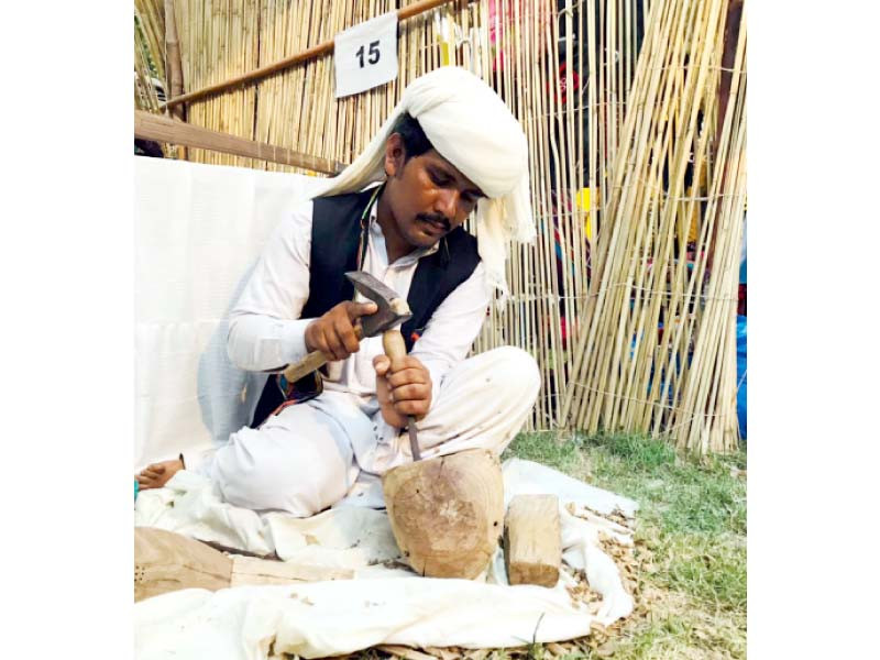 an artisan skillfully demonstrates a traditional art technique at lok virsa photo express