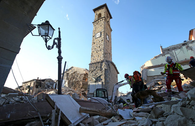 rescuers walk past the bell tower with the clock showing the time of the earthquake in amatrice central italy august 24 2016 photo reuters