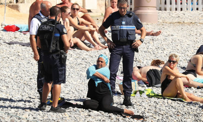 french police make woman resting on nice beach remove burkini french police make woman resting on nice beach remove burkini