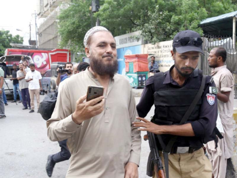 a policeman arrests an elderly pti supporter from outside the karachi press club photo jalal qureshi express