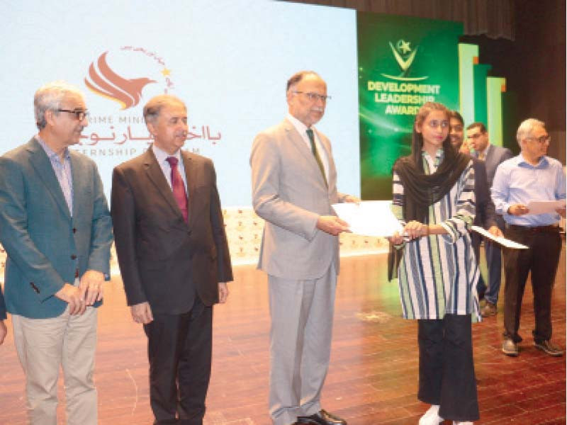 planning minister ahsan iqbal presents a young achiever with an award at a ceremony in the federal capital photo express