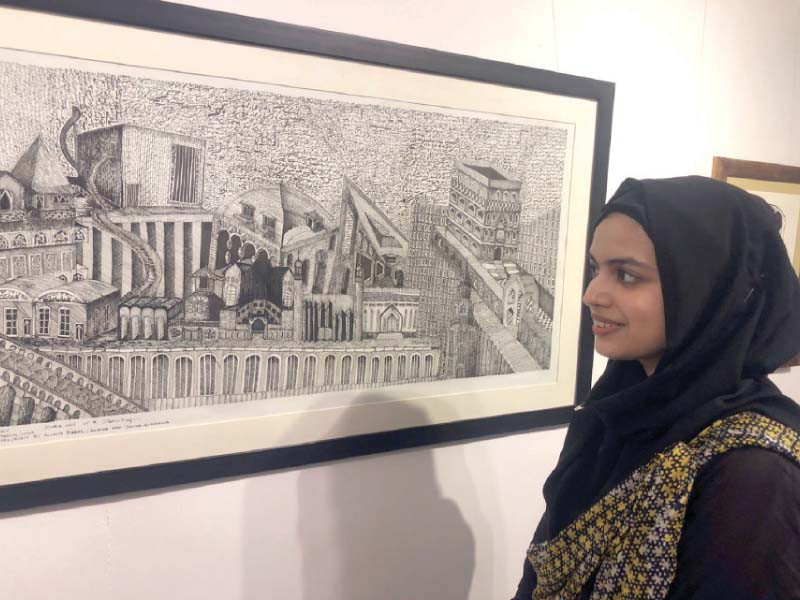 a visitor keenly observes art pieces on display at the artcade gallary in the federal capital photos express