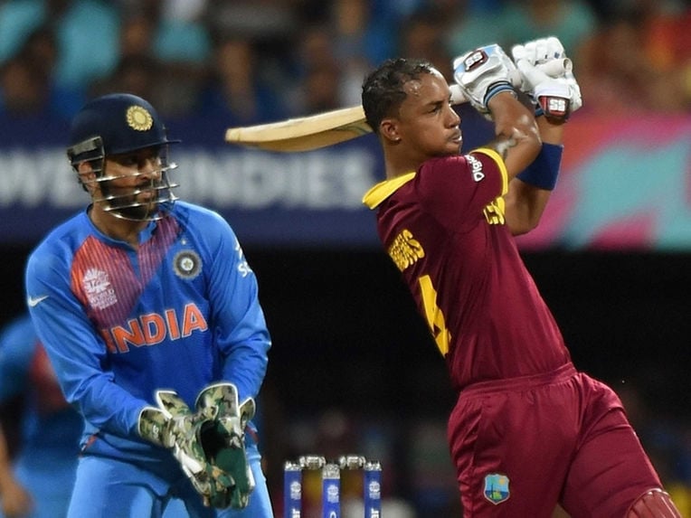 mahendra singh dhoni watches as lendl simmons hits a shot during world t20 semifinal photo afp