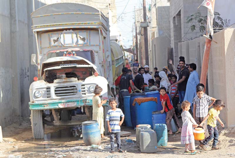 families buy water from a tanker due to shortage of the essential commodity in korangi photo aysha saleem express