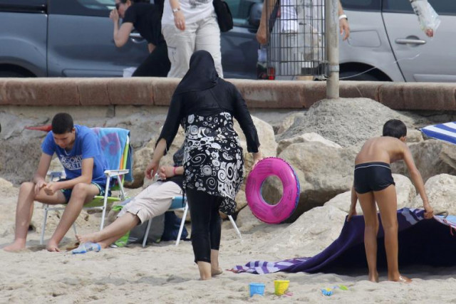 a muslim woman wears a burkini a swimsuit that leaves only the face hands and feet exposed on a beach in marseille photo reuters a muslim woman wears a burkini a swimsuit that leaves only the face hands and feet exposed on a beach in marseille photo reuters