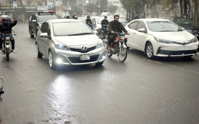 motorists on their way during a drizzle induced artificially in a part of lahore photo online motorists on their way during a drizzle induced artificially in a part of lahore photo online